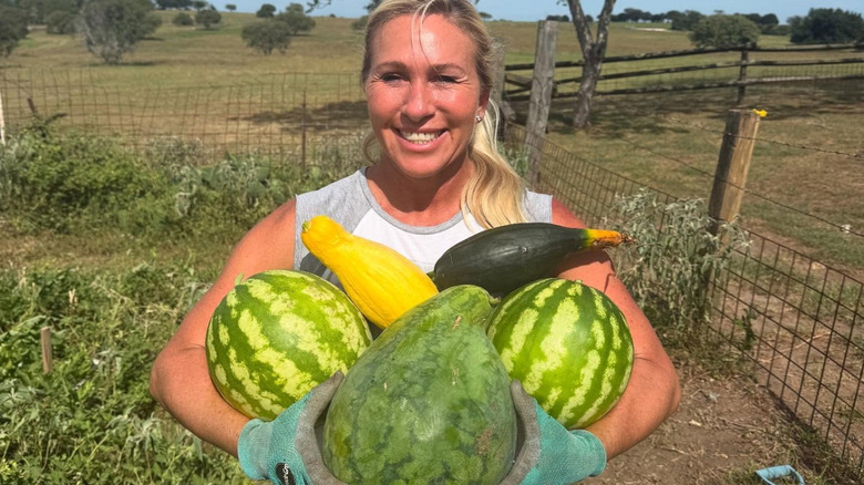 Marjorie Taylor Greene holding vegetables while smiling and looking at the camera
