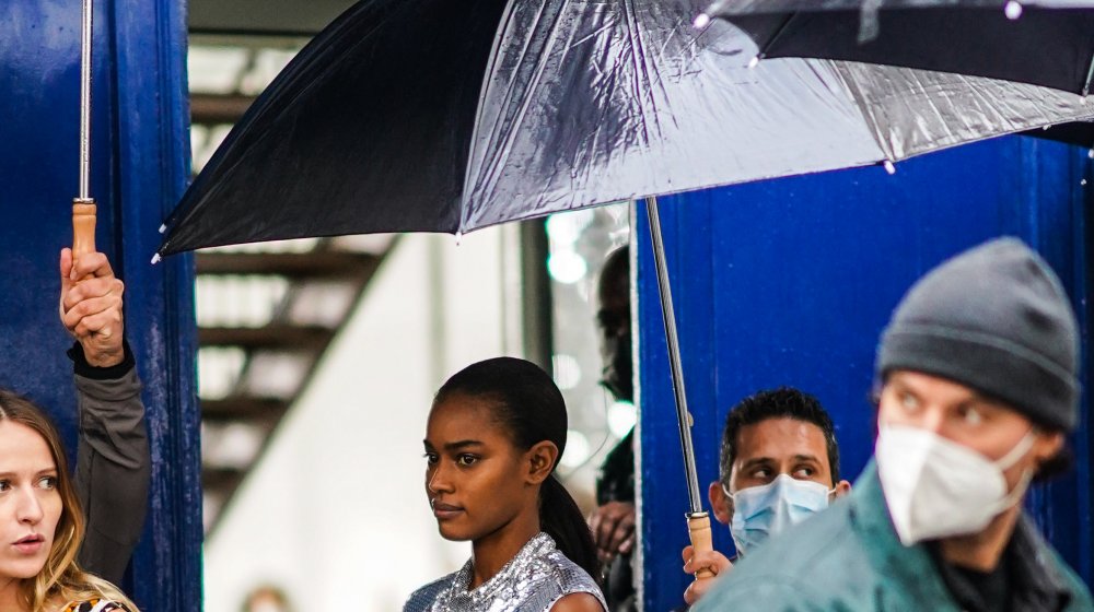 person with facemask on a rainy day