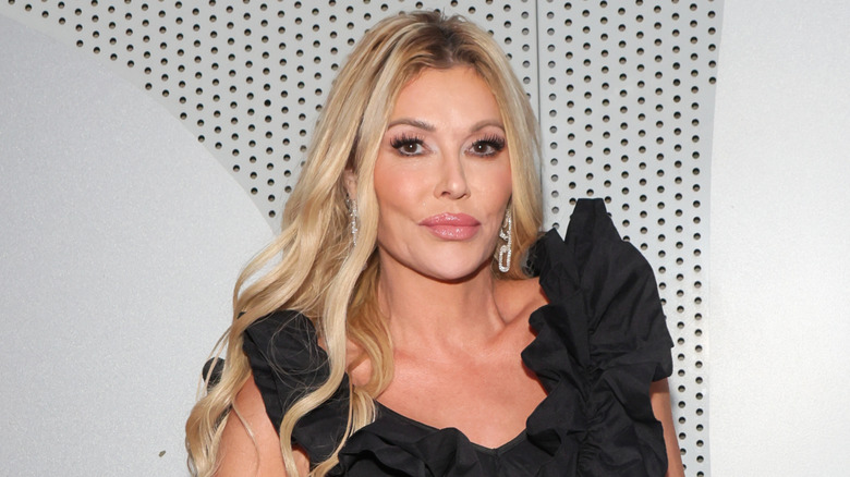 Brandi Glanville wearing a black dress with ruffles on the red carpet in April 2024.