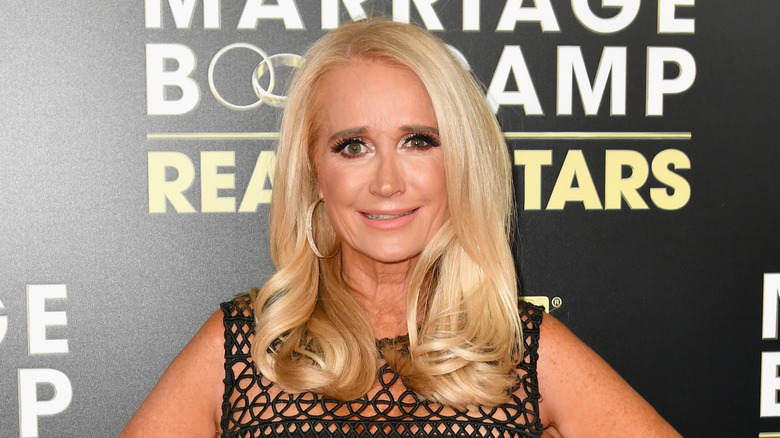 Kim Richards wearing a sheer black dress on the red carpet.
