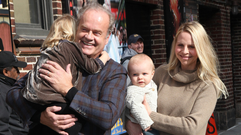 Smiling Kelsey Grammer and Kayte Walsh hold their children.