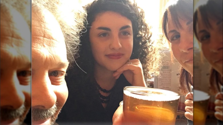 Curtis Armstrong smiles in a selfie holding a beer with his real-life daughter and wife