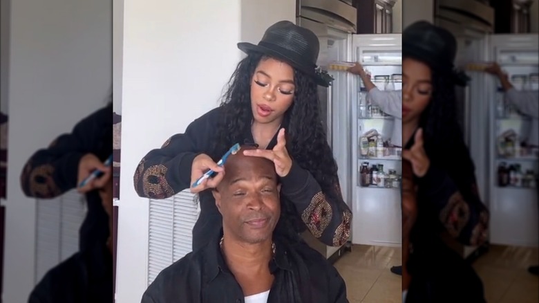 Damon Wayans Jr. sits with his eyes half closed while his daughter does his "hair"