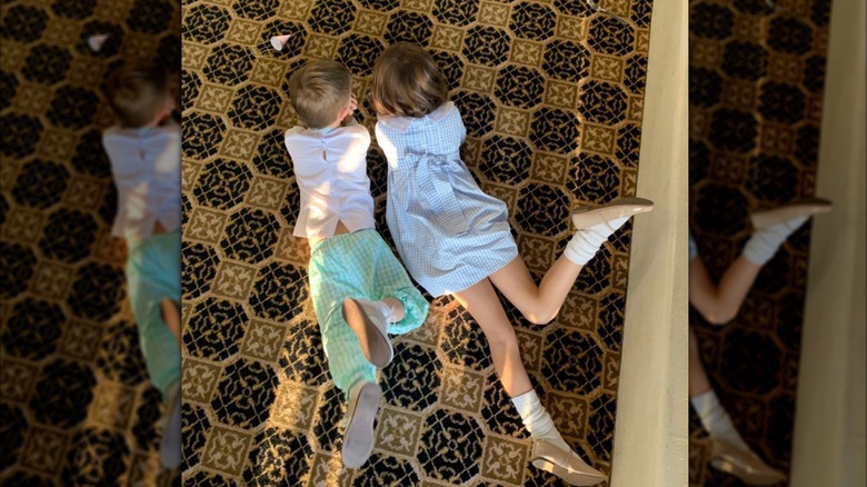 David Walton's two children lay on a patterned floor facing away from the camera