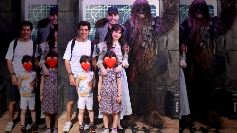 Zooey Deschanel stands with her hands on her daughter next to her ex-husband and boyfriend next to Chewbacca, and the kids have hearts covering their face