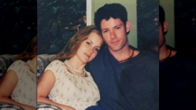 Amy Adams leaning her head on Darren Le Gallo's shoulder.