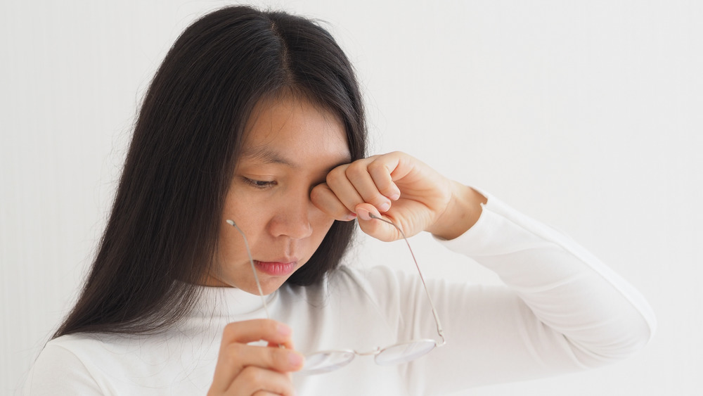 Woman scratching eyes