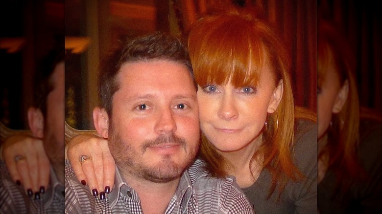 Throwback photo of Reba McEntire (R) with her arm around Brandon Blackstock (L)