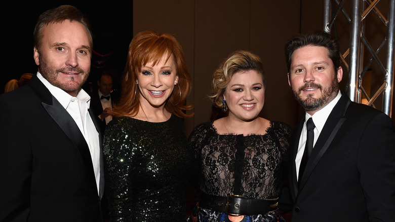 Narvel and Brandon Blackstock posing with Reba McEntire and Kelly Clarkson