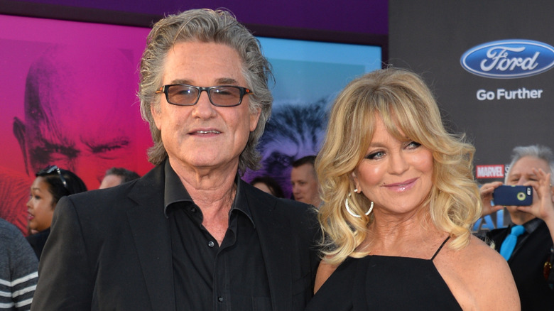 Kurt Russell looking thoughtful and Goldie Hawn smiling