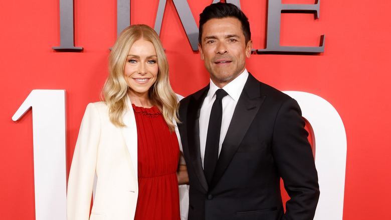 Kelly Ripa and Mark Consuelos posing for photos together at an event