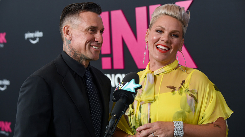 Pink with blonde hair in yellow dress with Carey Hart in black