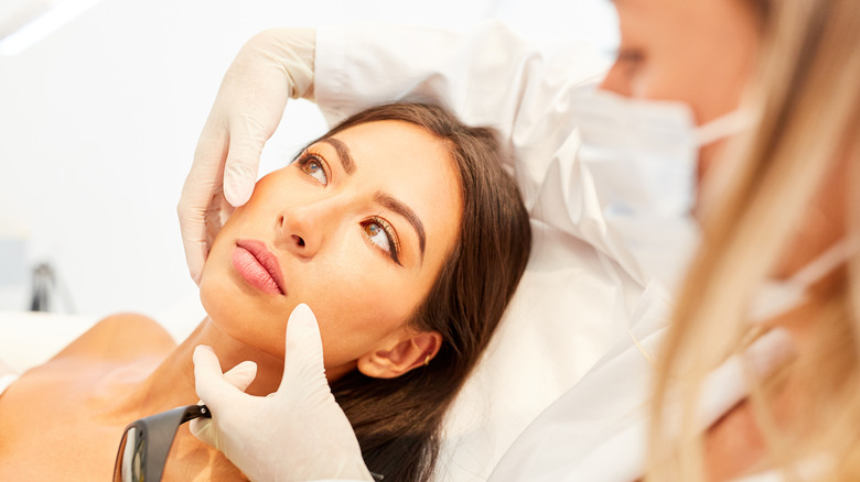 dermatologist inspects woman's face