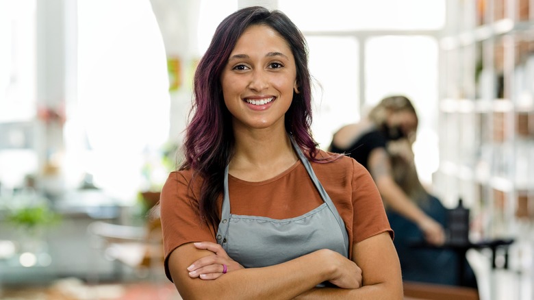 Smiling hairdresser with arms crossed