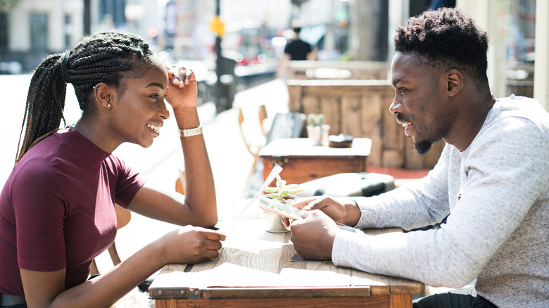 Man and woman smiling at outdoor restaurant