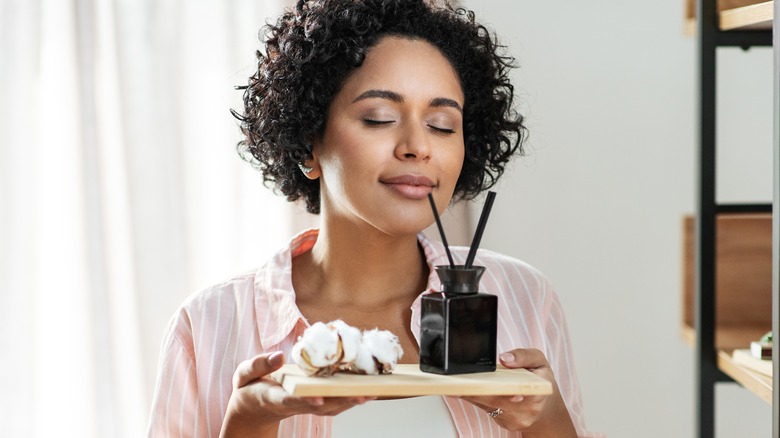 Woman sniffing reed diffuser