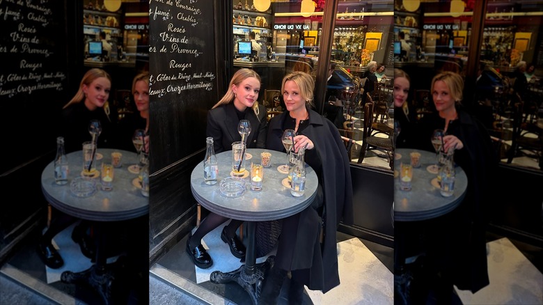 Ava Phillippe and Reese Witherspoon sitting down at table on vacation