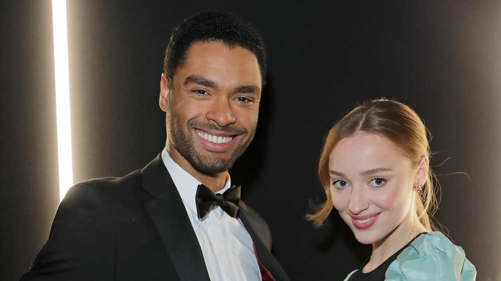 Regé-Jean Page smiling with Phoebe Dynevor