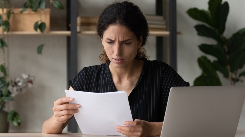 frustrated woman looking at paper