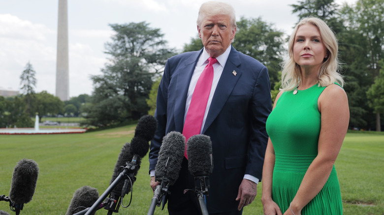 Karoline Leavitt standing next to Donald Trump during a press gaggle.