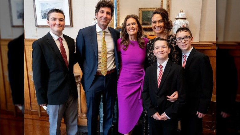 Bryan Chatfield Sanders, Sarah Huckabee Sanders, and Tiffany String pose for the camera (2025)