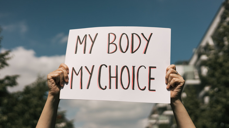 woman holding "my body my choice" protest sign