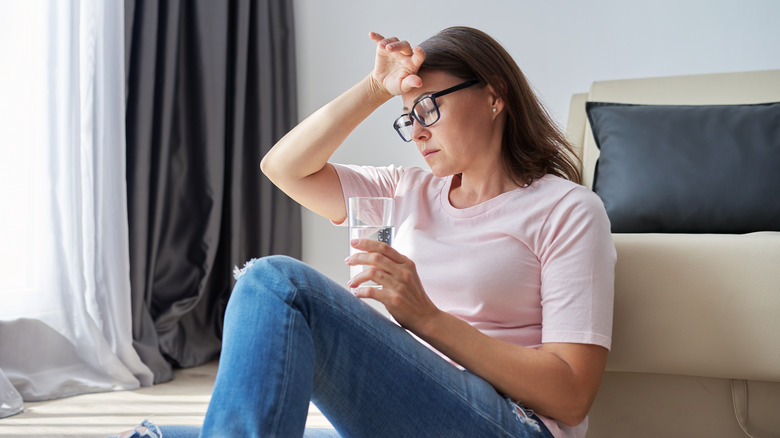 woman looking ill water glass