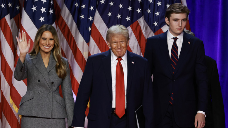 Melania Trump waving while Donald Trump and Barron Trump stand
