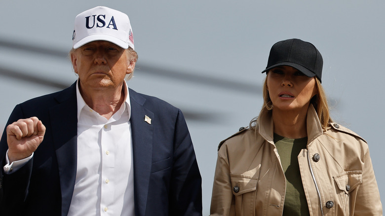 Melania Trump and Donald Trump walking next to each other while holding hands at an Air Force base.