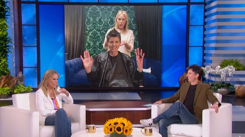 Cheryl Hines and Tig Notaro on The Ellen Show with a photo of Hines cutting Notaro's hair in the background