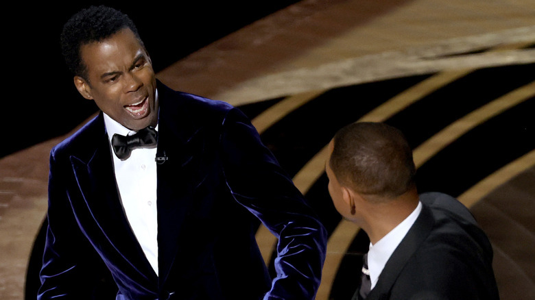 Chris Rock reacts to being slapped by Will Smith onstage at the Oscars