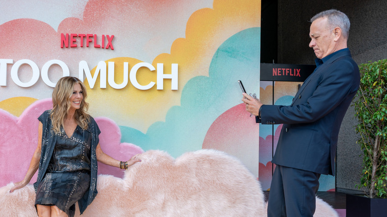 Tom Hanks taking a photo of Rita Wilson at an event for Netflix's Too Much