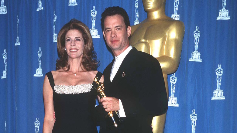Tom Hanks clutching an Oscar besides a smiling Rita Wilson in 1995
