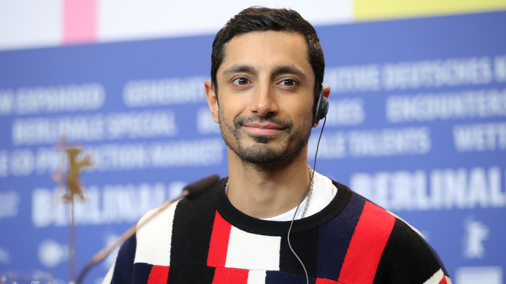 Riz Ahmed smiling with earpiece