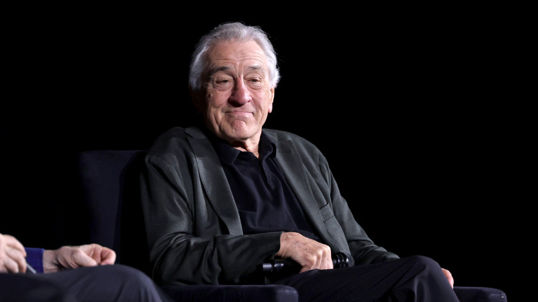 Robert De Niro sitting and smiling