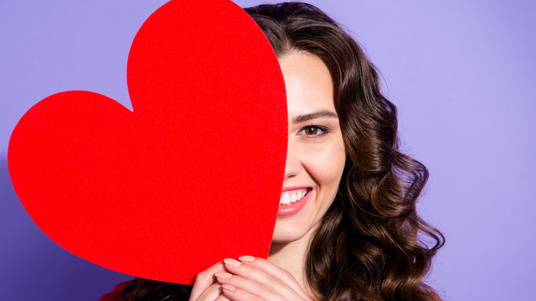 woman with romantic wavy hair holding heart