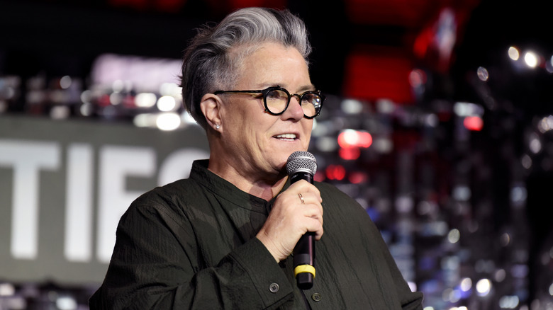 Rosie O'Donnell smiling with microphone in hand
