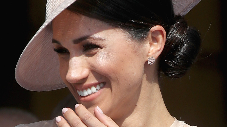 Meghan Markle laughs in a hat