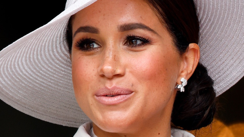 Meghan Markle purses her lips