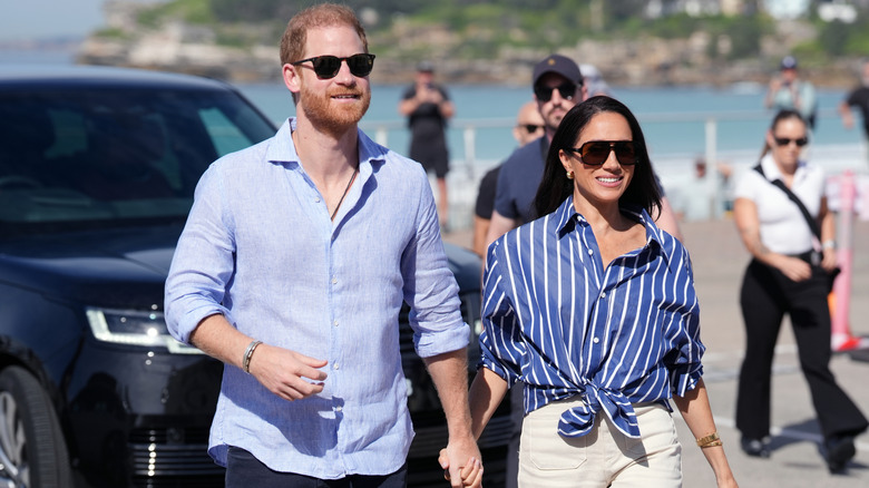 A smiling Prince Harry and Meghan Markle holding hands
