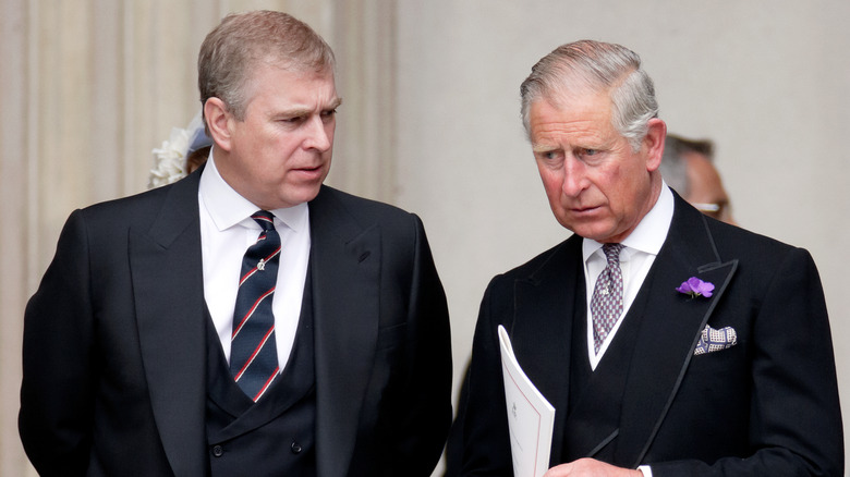 Prince Andrew talking to King Charles and Charles looking unhappy