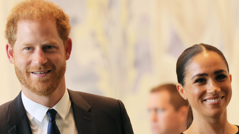 Prince Harry and Meghan Markle smiling at an event