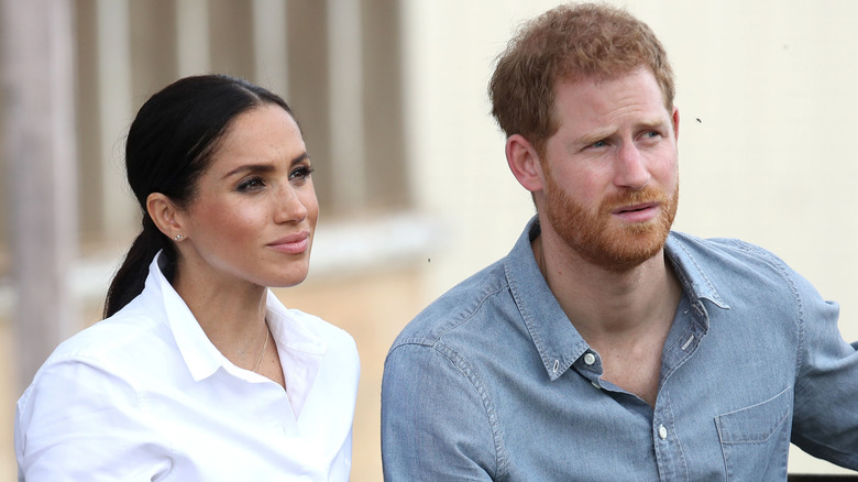 Prince Harry and Meghan Markle looking concerned