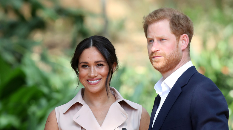 Meghan Markle and Prince Harry grinning for a camera