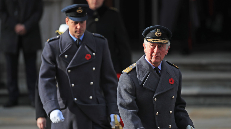 Prince William walking behind King Charles