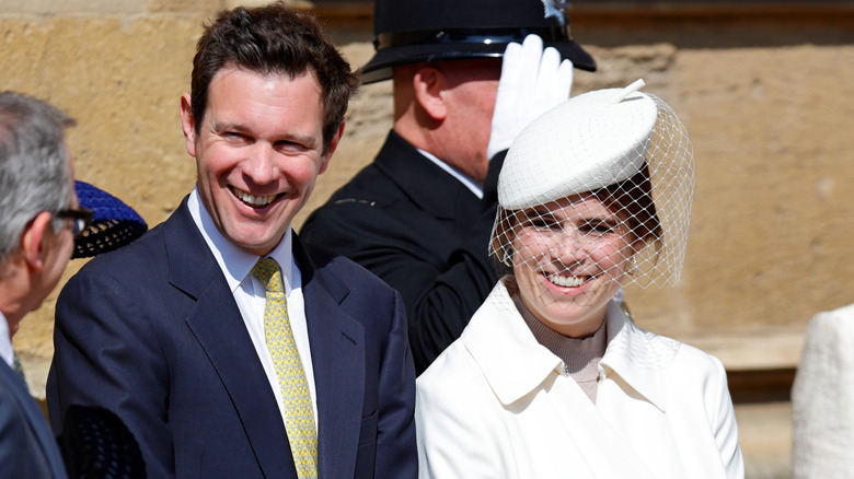Jack Brooksbank in blue suit and Princess Eugenie in white with veiled hat