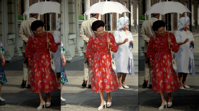 Princess Margaret wearing a red polka dot dress while holding an umbrella