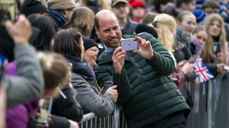 Prince William taking a photo with fans