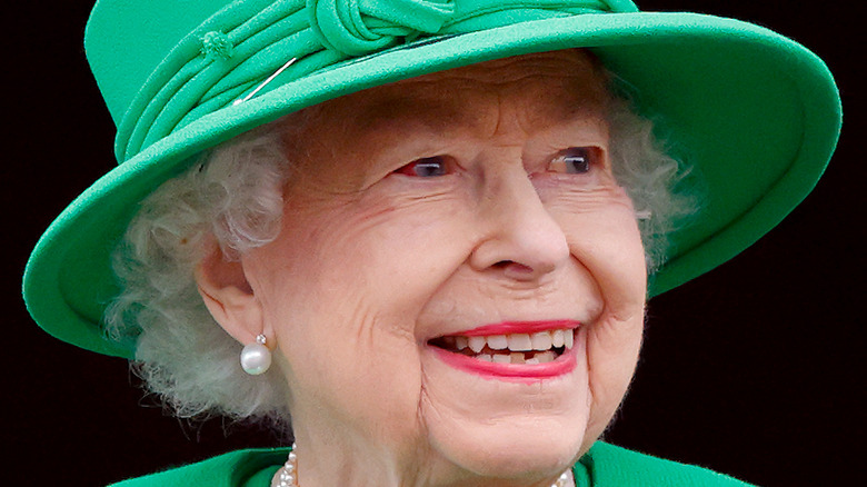 Queen Elizabeth smiling in bright green hat