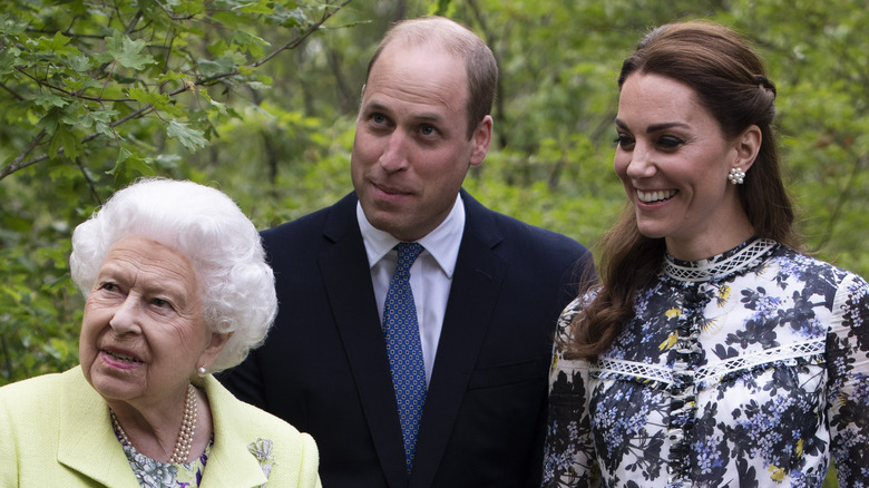 Queen Elizabeth, Prince William, and Kate Middleton smiling for a group photo